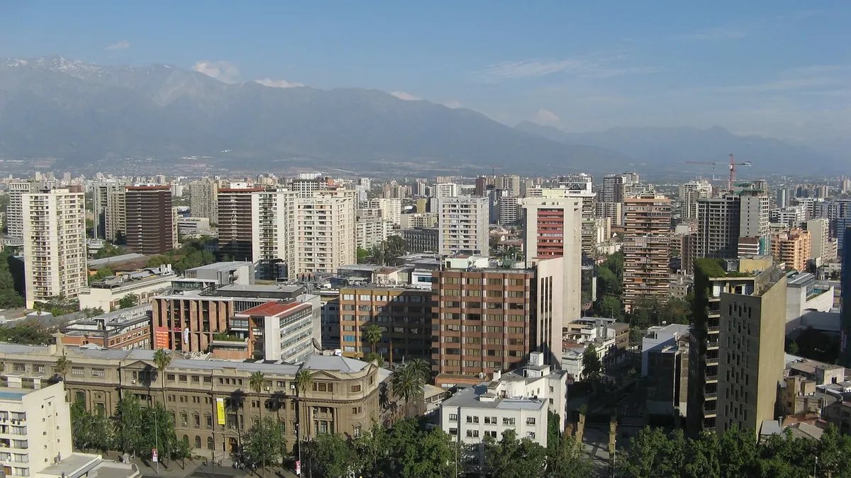 Imagem ilustrativa: Vista urbana de Santiago com trabalhadores e trânsito, como ilustração do cenário econômico chileno