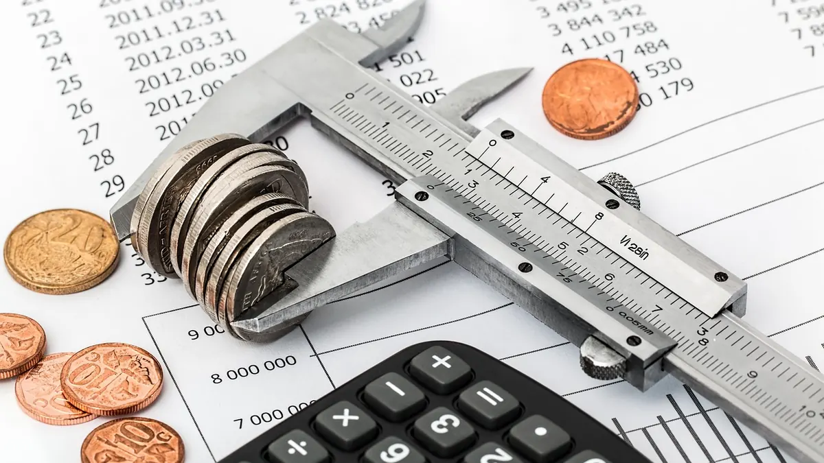 Imagem ilustrativa: Documentos financeiros e calculadora sobre uma mesa, representando a dívida pública