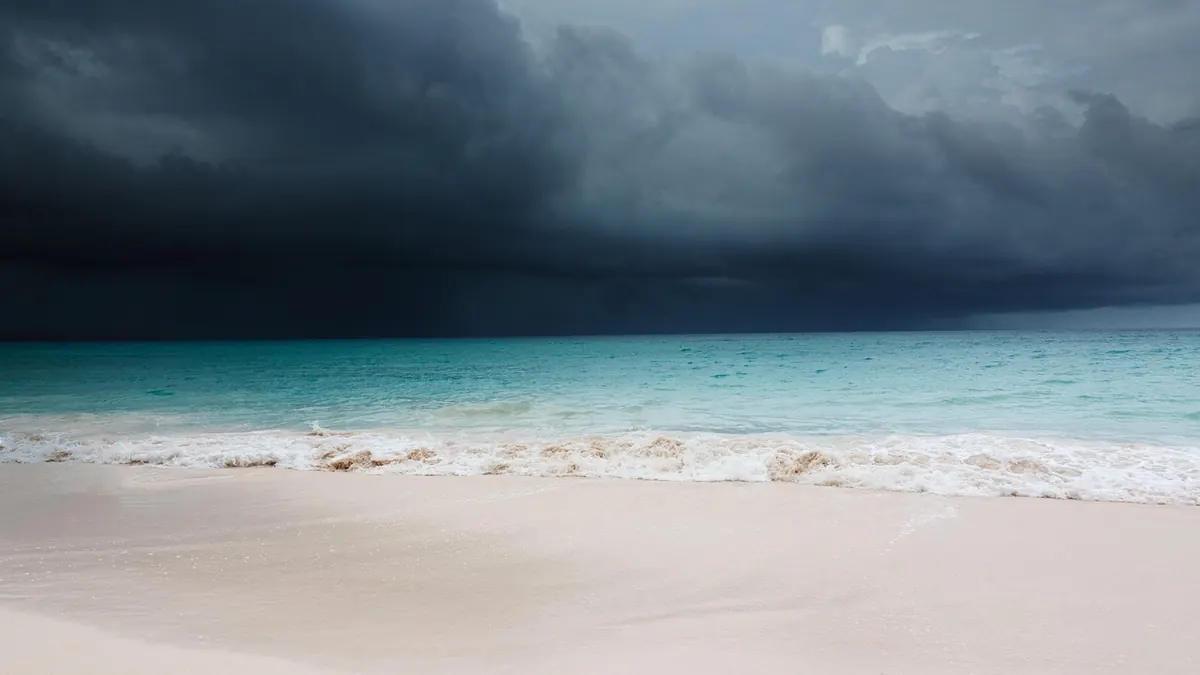Imagem ilustrativa: Costa da Flórida sob a aproximação de um furacão, com céu carregado e mar agitado