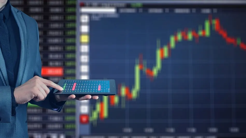 Imagem ilustrativa: Painel eletrônico com cotações da bolsa de valores e investidores acompanhando o mercado