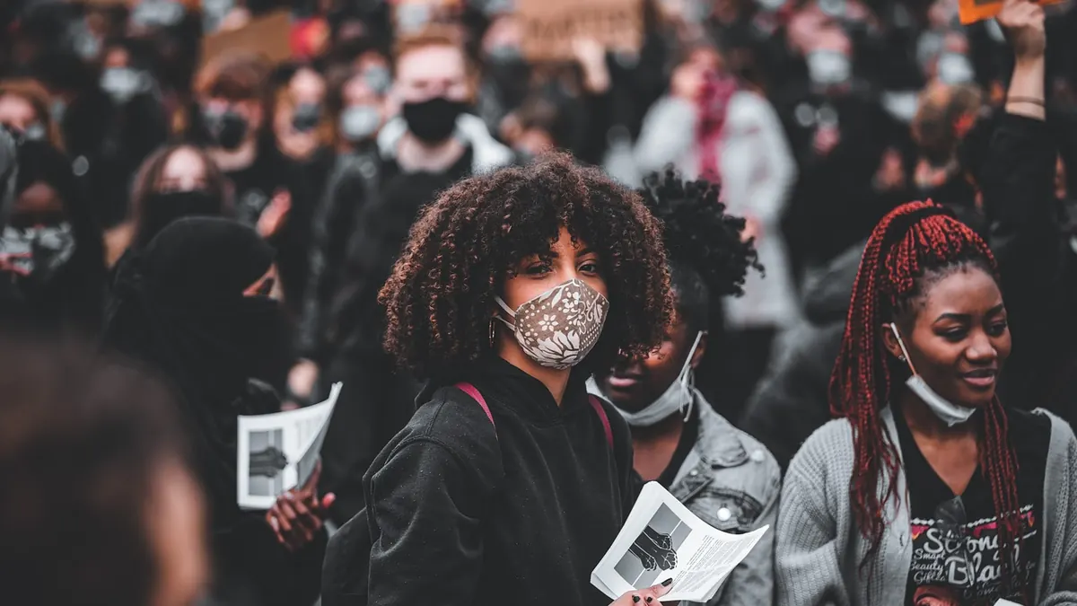 Imagem ilustrativa: Jovens e trabalhadores em uma manifestação pacífica em uma avenida urbana