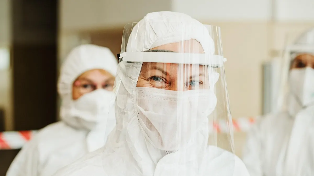 Imagem ilustrativa: Profissionais de saúde usando equipamentos de proteção em uma área de atendimento hospitalar