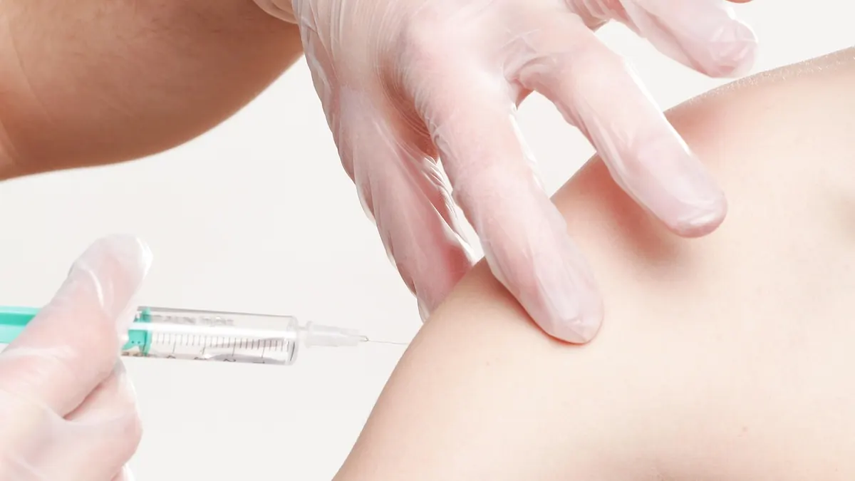 Imagem ilustrativa: Profissional de saúde aplicando vacina em uma criança em uma unidade de vacinação